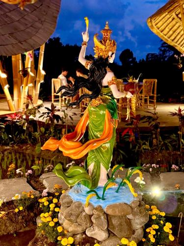 a statue of a mermaid in a garden at Green Lander Ubud in Ubud