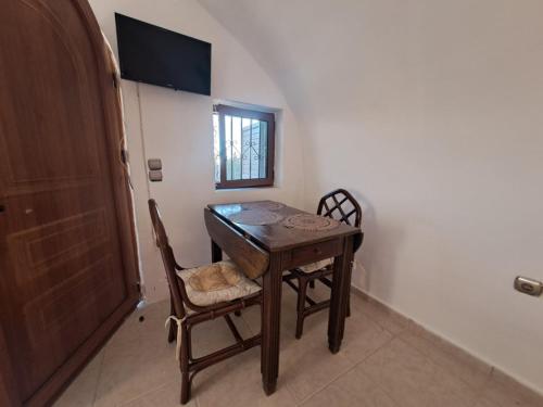 a dining room table with two chairs and a window at Mani Spot Katerina in Poliána