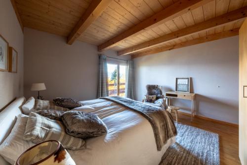 a bedroom with a large bed and a window at Chalet Occursus Anzère in Anzère