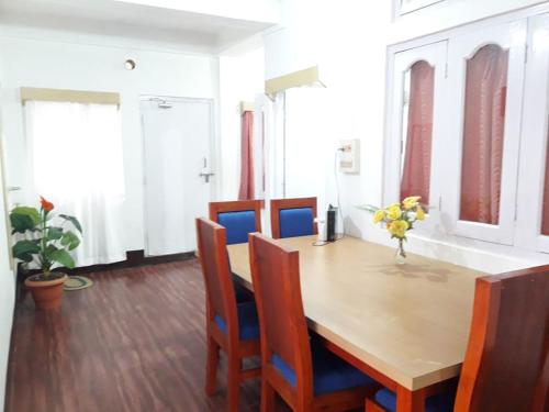 a dining room with a wooden table and chairs at Bliss Homestay in Tawang