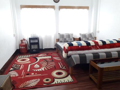 a living room with a couch and a bed and a rug at Bliss Homestay in Tawang