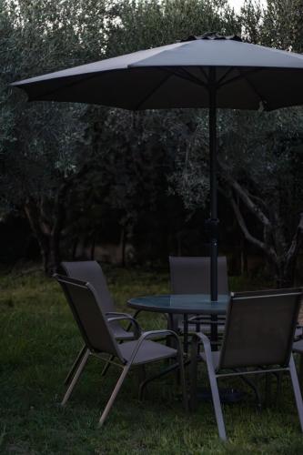 two chairs and a table with an umbrella at Diame Suite in Chrysoupolis