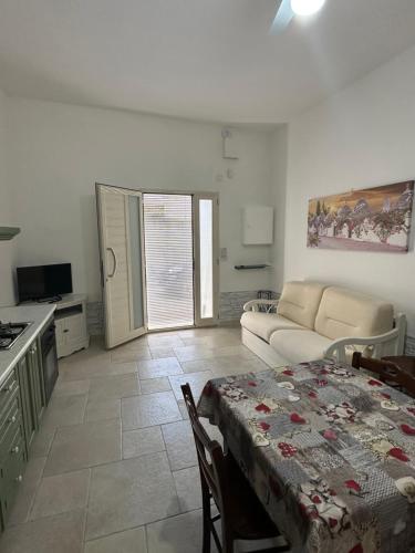 a kitchen and a living room with a table and a couch at BRUNETTI HOLIDAY due in Torre Ovo