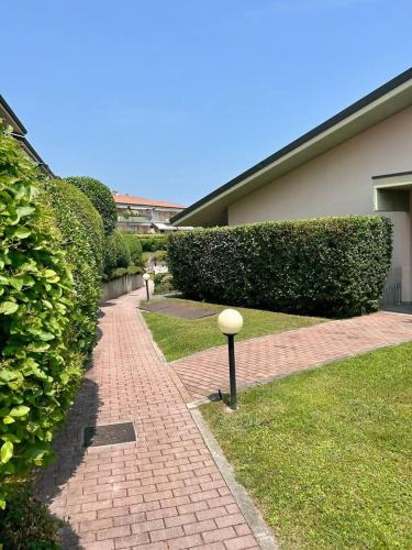 a brick walkway in front of a building with bushes at Residenza Kristall Lago in Desenzano del Garda