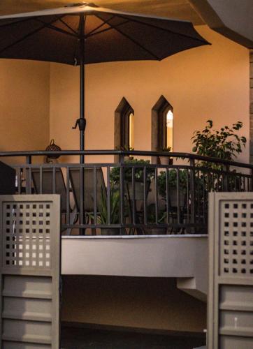 a balcony with a table and an umbrella at Diame Suite in Chrysoupolis