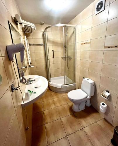 a bathroom with a shower and a toilet and a sink at Gościniec Sucholeski in Suchy Las