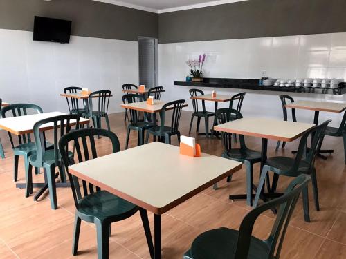 a restaurant with tables and chairs in a room at Hotel Alvorada in Batatais