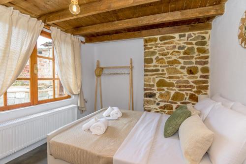 una cama en una habitación con una pared de piedra en Plismoní, en Alexandroupoli