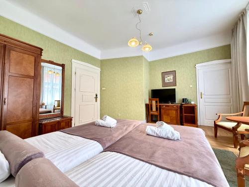 a bedroom with two beds with towels on them at Hotel - Pokoje i Apartamenty Heban in Toruń