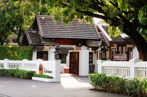 a small white building with a black roof at Rimping Village in Chiang Mai