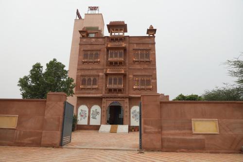 an old brick building with a gate in front of it at Pithoragarh Resort in Jodhpur