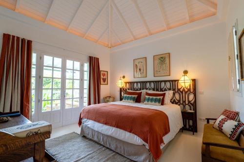 a bedroom with a large bed and a couch at 1493 VILLA & LODGES st barth in Anse des Cayes