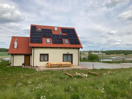a house with solar panels on the roof at Pęglity jezioro in Gietrzwałd
