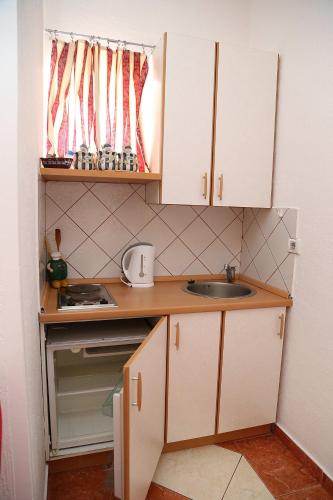 a small kitchen with a sink and a window at Apartments Stevo Nikočević in Bar