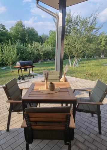 a wooden table and chairs on a patio with a grill at TETRA Plus 569 in Breaza