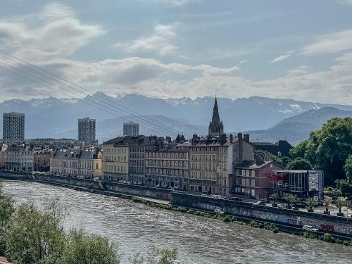 a view of a city with a river and a train at Le Petit Perrière - HyperCentre - Quai de Grenoble in Grenoble
