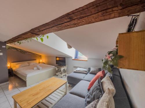 a attic bedroom with a bed and a living room at Le Petit Perrière - HyperCentre - Quai de Grenoble in Grenoble