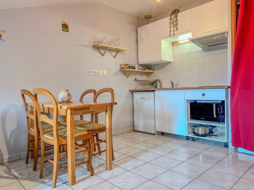 a kitchen with a wooden table and chairs in a kitchen at Le Petit Perrière - HyperCentre - Quai de Grenoble in Grenoble