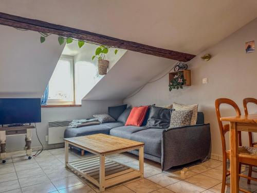 a living room with a couch and a table at Le Petit Perrière - HyperCentre - Quai de Grenoble in Grenoble