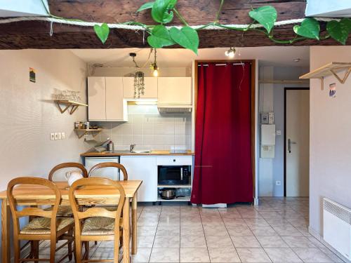 a kitchen with a red door and a table and chairs at Le Petit Perrière - HyperCentre - Quai de Grenoble in Grenoble