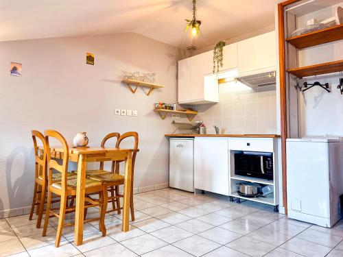 a kitchen with a table and chairs and a refrigerator at Le Petit Perrière - HyperCentre - Quai de Grenoble in Grenoble