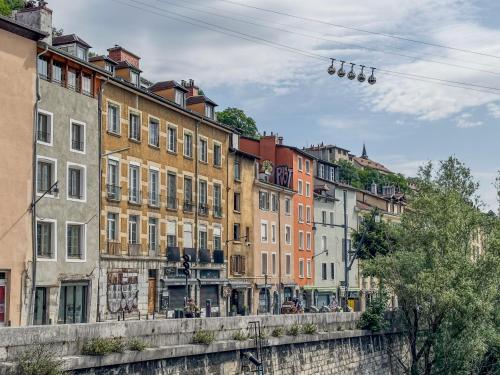 a row of buildings next to a river at Le Petit Perrière - HyperCentre - Quai de Grenoble in Grenoble