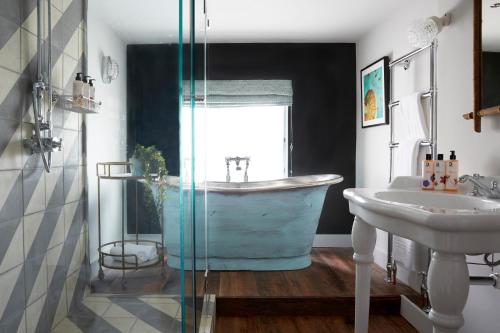 a bathroom with a bath tub and a sink at Artist Residence Cornwall in Penzance
