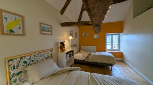 a bedroom with two beds and a window at Dépendance du château de Remehan rénovée avec goût in Pouru-Saint-Rémy