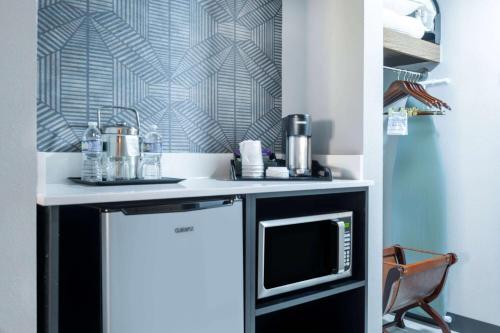 a kitchen with a counter with a microwave at Wyndham Indianapolis Airport in Indianapolis