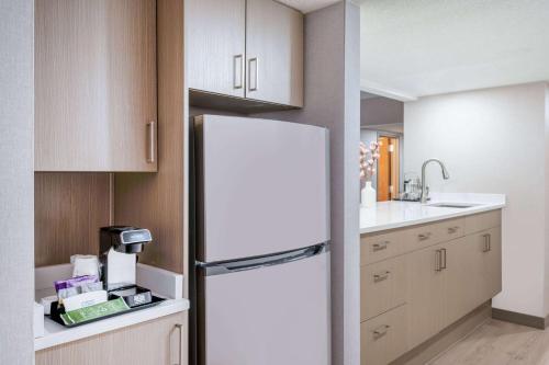 a kitchen with a refrigerator and a sink at Wyndham Indianapolis Airport in Indianapolis