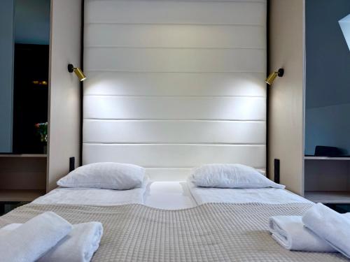 a bedroom with two beds with white pillows at Hotel - Pokoje i Apartamenty Heban in Toruń