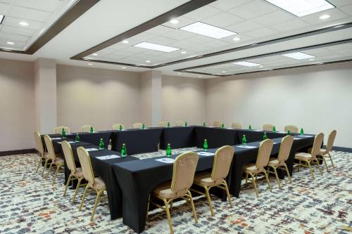 a conference room with a long table and chairs at Wyndham Indianapolis Airport in Indianapolis
