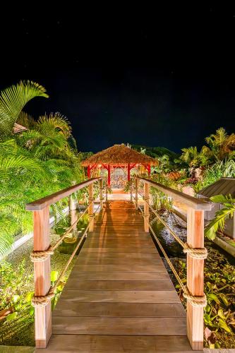 a wooden walkway leading to a resort at night at 1493 VILLA & LODGES st barth in Anse des Cayes