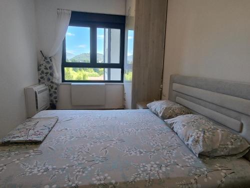 a bedroom with a large bed with a window at Sunčano Jutro in Trebinje