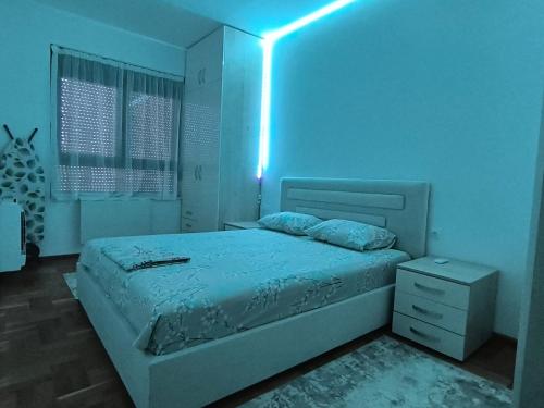 a bedroom with a bed with a blue light on it at Sunčano Jutro in Trebinje