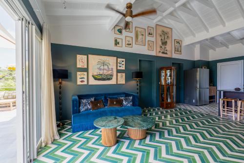 a living room with a blue couch and a table at 1493 VILLA & LODGES st barth in Anse des Cayes