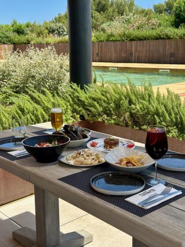 a table with plates of food and glasses of wine at Silken Platja d'Aro in Platja  d'Aro