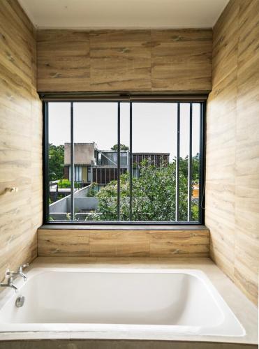a large white bath tub in a room with a window at Hyde198homeresort in Ban Rai Khlong Sai
