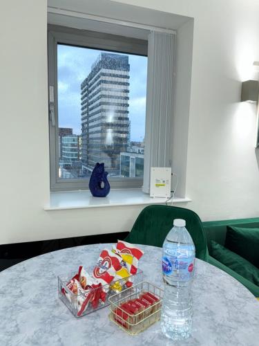 a table with a bottle of water and snacks on it at Winners of 2025 traveller Award, Elegant two bedroom city central apartment with Netflix & WiFi in Leeds