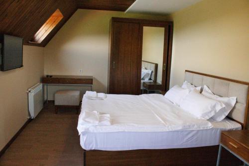a bedroom with a large white bed and a desk at Hotel Marani Sanavardo 