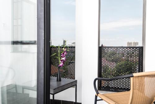 a balcony with a chair and a table and a window at Aquarius Hotel and Urban Resort in Phnom Penh