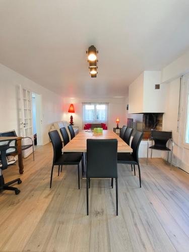 une salle à manger avec une table et des chaises en bois dans l'établissement Villa 15 pers - Jardin Arbore - Calme - Parking, à Pau