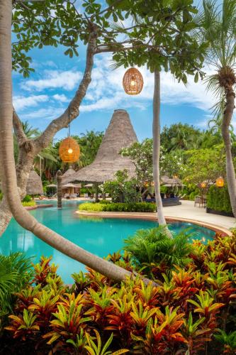 a pool at a resort with palm trees at Anantara Hua Hin Resort in Hua Hin