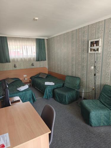 a hotel room with two beds and a table at Noviz Hotel in Plovdiv
