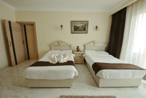 two beds in a hotel room with towels on them at Hollywood Aqua Park Sharm El-Sheikh in Sharm El Sheikh