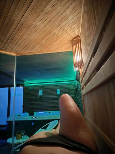 a person laying on a bed in a room at Haie Jad'Ô in Hamois