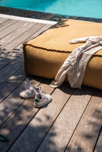 a pair of shoes on a wooden floor next to a bed at Maison Hyacinthe in Saint-Pierre-Langers