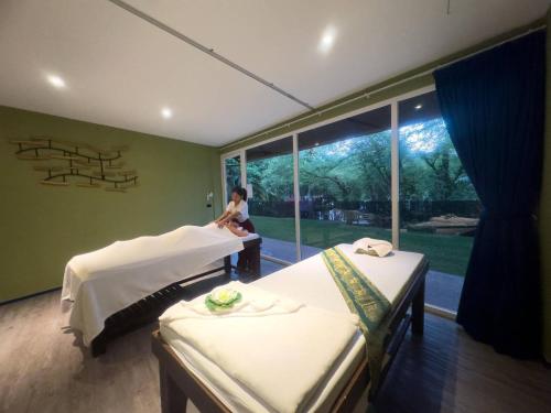 una donna seduta in una stanza con due letti di Chillax Luxury Pool Villa - Koh Chang a Ban Khlong Son