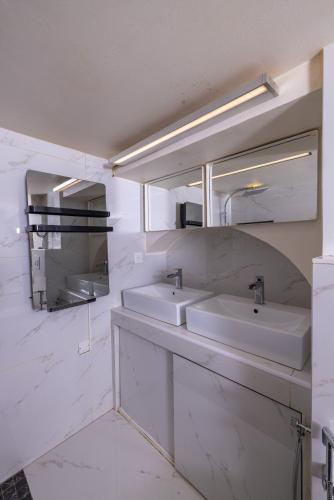 a white bathroom with two sinks and a mirror at Duplex suite 50m de la plage Carré d'Or Nice in Nice