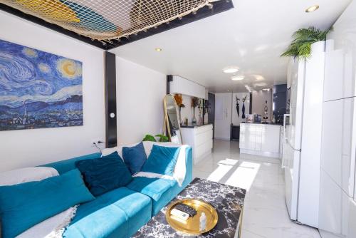 a living room with a blue couch and a kitchen at Duplex suite 50m de la plage Carré d'Or Nice in Nice